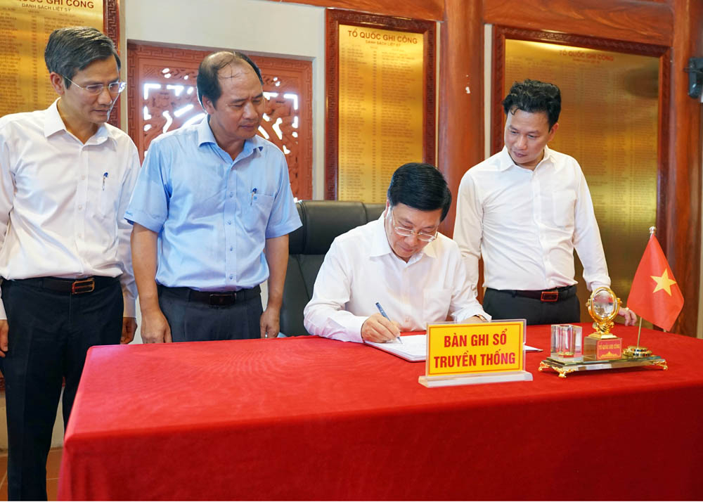 Phó Thủ tướng Thường trực Chính phủ Phạm Bình Minh ghi lưu bút vào Sổ vàng truyền thống tại Nghĩa trang Liệt sỹ Quốc gia Vị Xuyên.