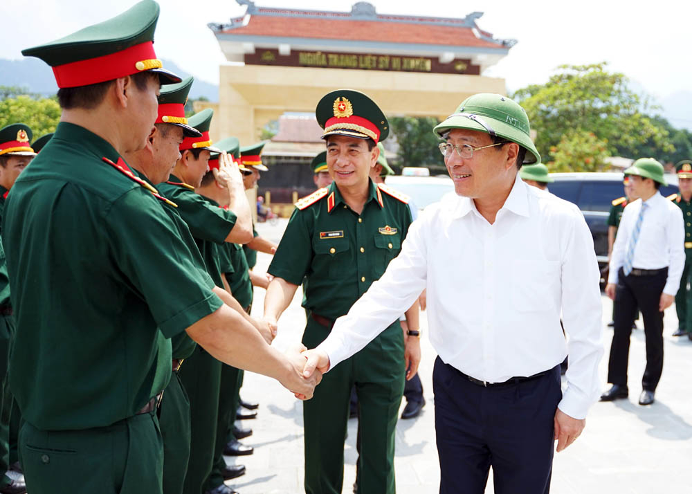 Phó Thủ tướng Thường trực Chính phủ Phạm Bình Minh và Bộ trưởng Bộ Quốc phòng Phan Văn Giang với lực lượng vũ trang của tỉnh. 