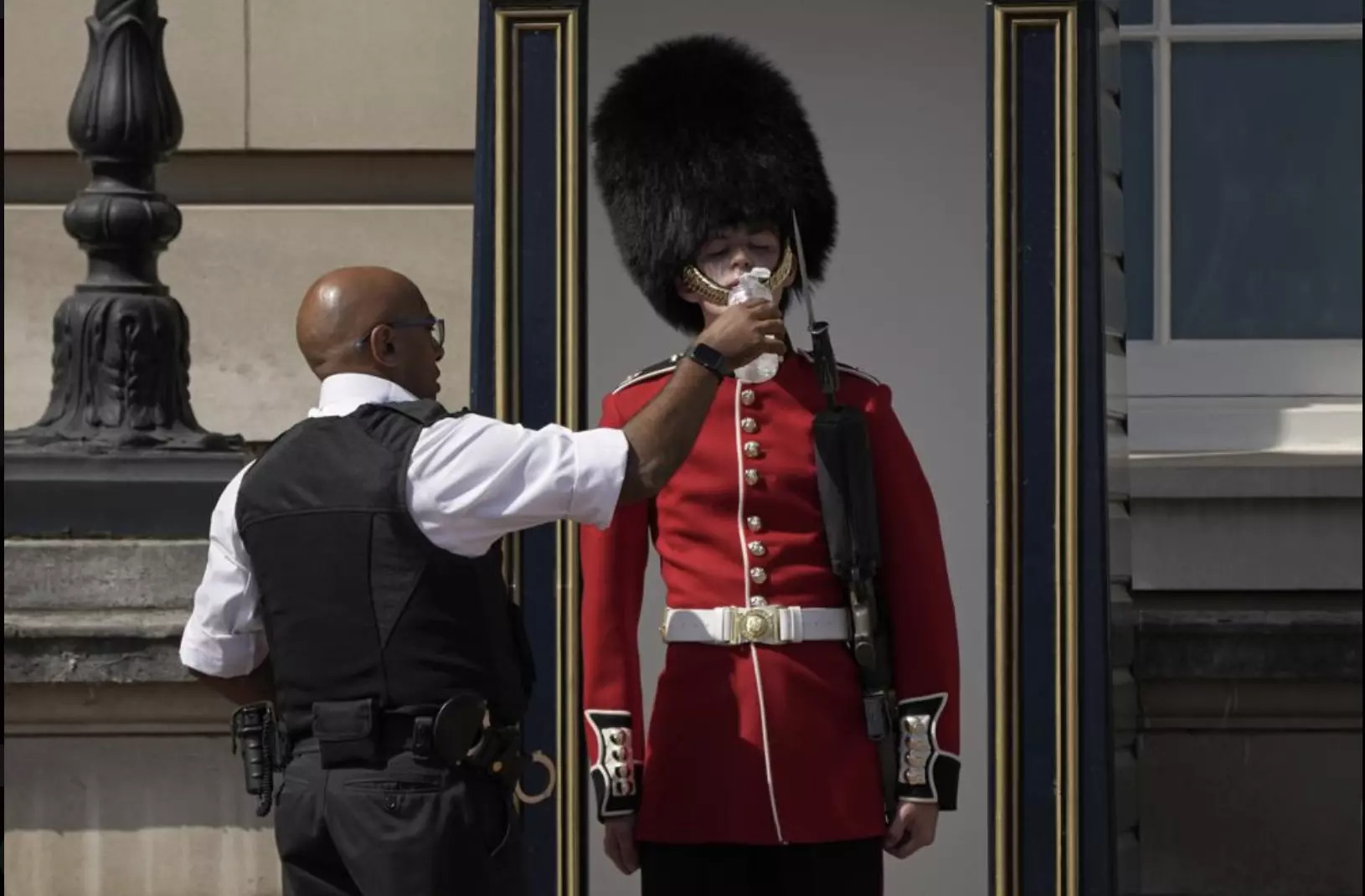 Lính canh tại Cung điện Buckingham đã phá vỡ chủ nghĩa chấp nhận nghịch cảnh như thường lệ của họ để uống từng ngụm nước. Ảnh: AP