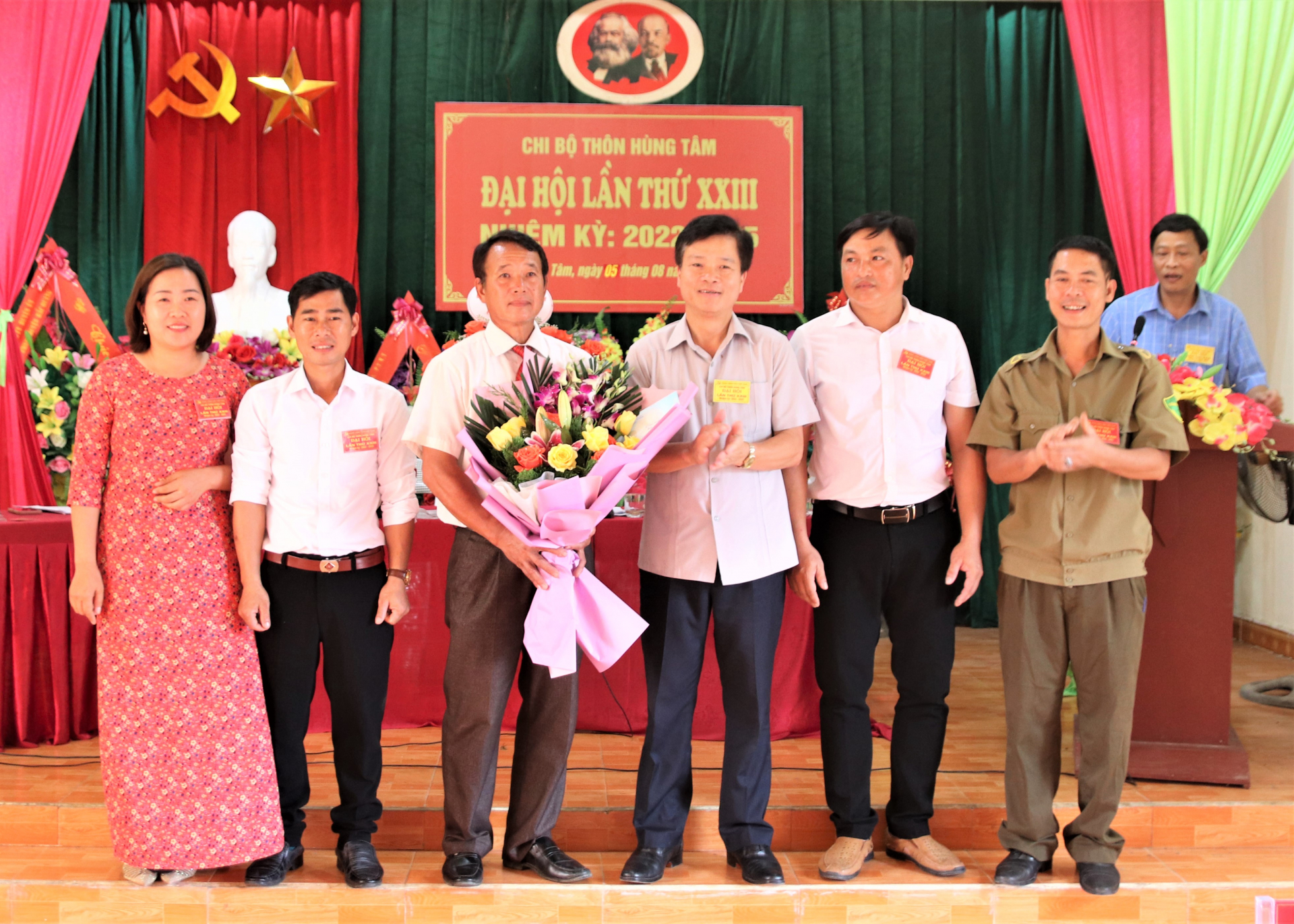 Chủ nhiệm Ủy ban Kiểm tra Tỉnh ủy Trần Quang Minh tặng hoa và quà chúc mừng Chi ủy Chi bộ thôn Hùng Tâm khóa mới.