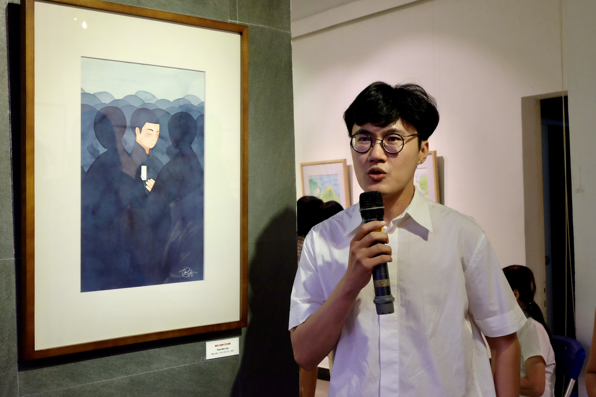 Họa sĩ trẻ Phạm Minh Tuân cùng tác phẩm Màu xanh cô đơn.