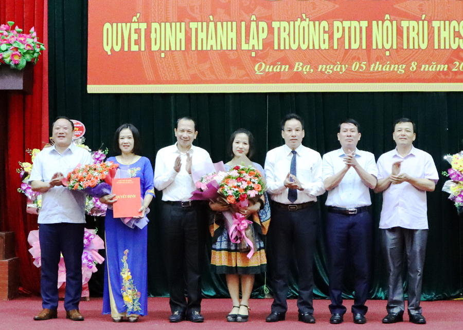 Đồng chí Trần Đức Quý, Tỉnh ủy viên, Phó Chủ tịch UBND tỉnh trao Quyết định và tặng hoa chúc mừng Ban Giám hiệu nhà trường.