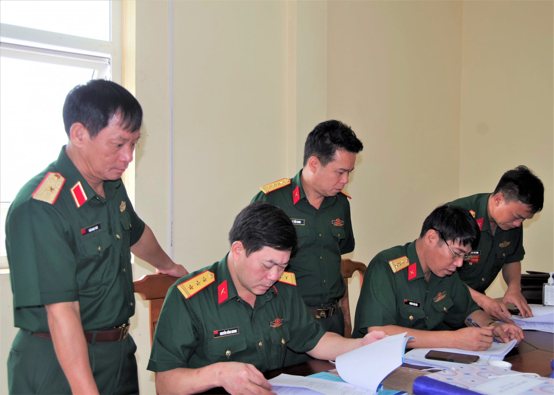 Thiếu tướng Trần Ngọc Tuấn và Đại tá Lại Tiến Giang theo dõi, chỉ đạo kiểm tra hệ thống văn bản, sổ sách tại Ban CHQS huyện Bắc Quang.