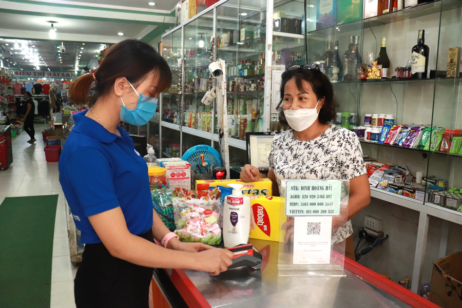 Khách hàng quẹt thẻ ATM thanh toán qua máy POS của Agribank được lắp đặt tại siêu thị Hải Lan, thị trấn Việt Quang.