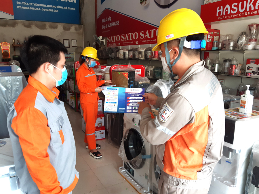 Nhân viên Điện lực Quang Bình tuyên truyền người dân tại tổ 2, thị trấn Yên Bình sử dụng tiết kiệm điện.