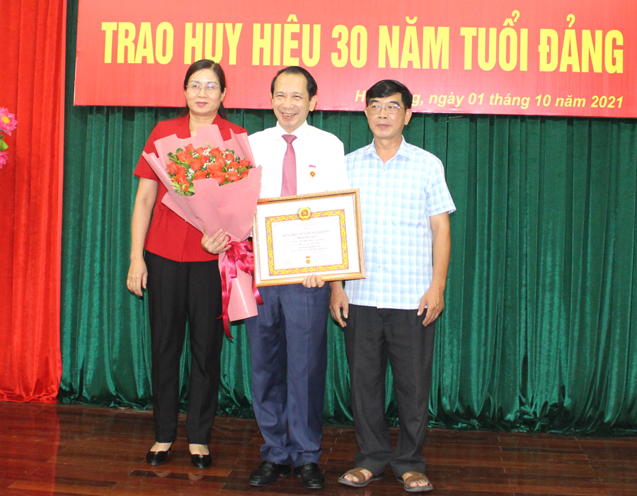 Phó Chủ tịch UBND tỉnh Hà Thị Minh Hạnh và lãnh đạo Đảng ủy Khối Cơ quan - Doanh nghiệp tỉnh tặng hoa chúc mừng đồng chí Trần Đức Quý.
