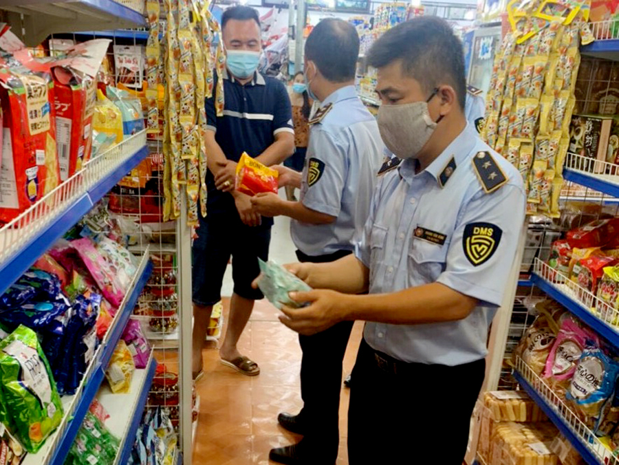 Cán bộ Đội Quản lý thị trường số 3 kiểm tra cửa hàng bán nhu yếu phẩm tại thị trấn Việt Quang (Bắc Quang).