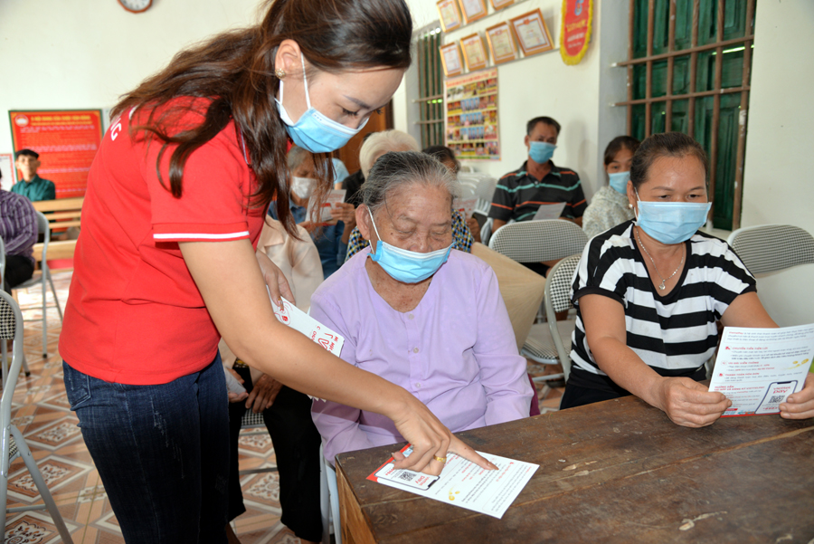 Nhân viên Viettel Hà Giang hướng dẫn người dân thôn Vĩnh Tâm, xã Vĩnh Phúc (Bắc Quang) thanh toán tiền điện qua điện thoại.