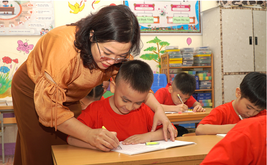 Cô giáo Trường Tiểu học Trần Phú, Tp. Hà Giang đang giúp đỡ em Nguyễn Ngọc Nam Phong, một học sinh từ Hà Nội đang theo học lớp 1 tại trường.