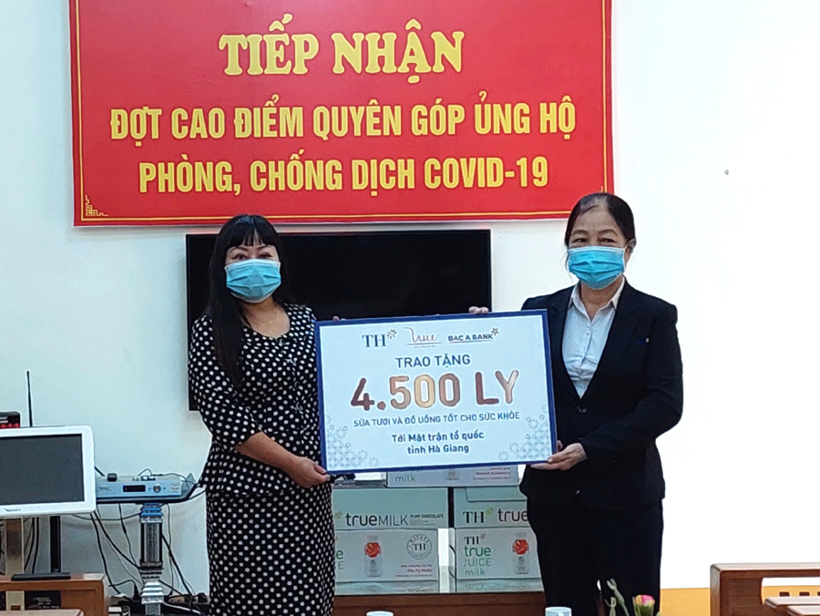Bà Trần Thị Bình (bên phải), đại diện Tập đoàn TH True Milk trao 4.500 ly sữa tươi cho Uỷ ban MTTQ tỉnh