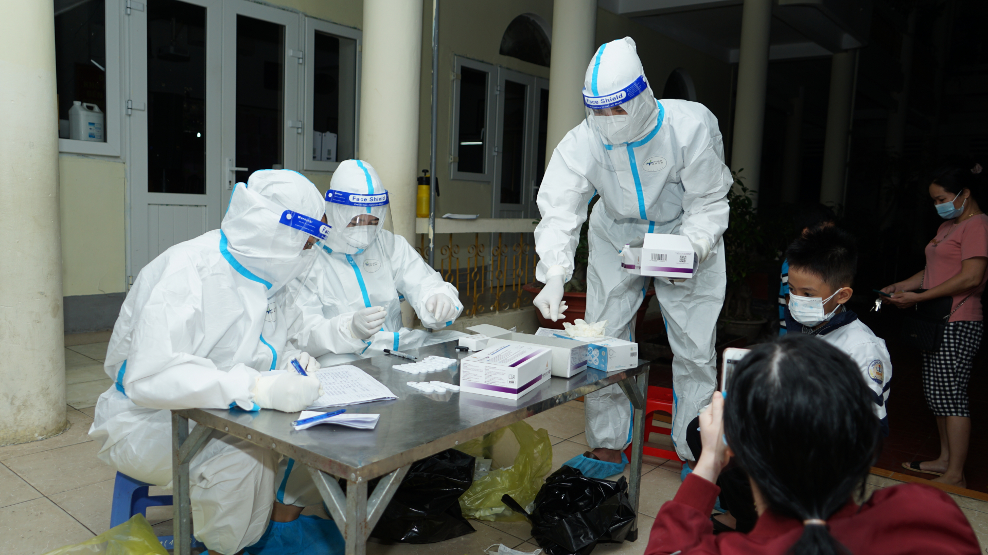 Nhân viên y tế đang test cả buổi tối chạy đua với thời gian  để sớm truy vết, khoanh vùng, dập dịch tại trường tiểu học Trần Phú
