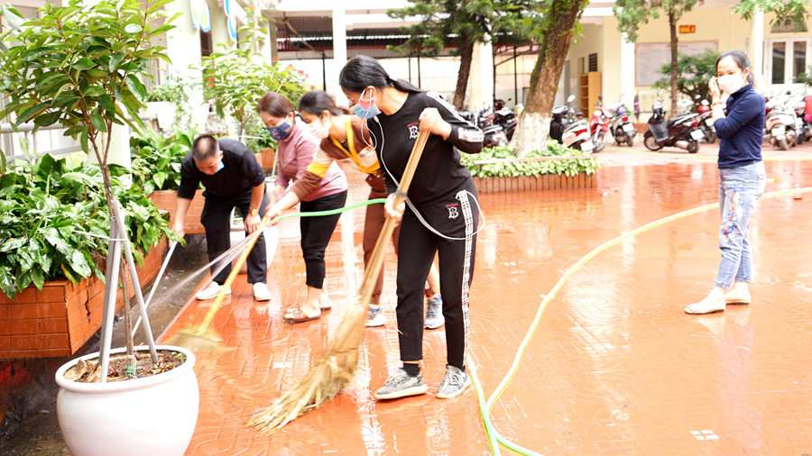 Các Thầy, cô giáo Trường Tiểu học Lê Lợi đang vệ sinh khuôn viên sân trường chuẩn bị đón các em học sinh quay lại trường học.