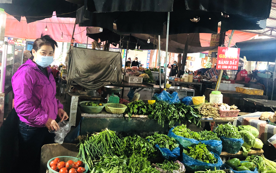 Cô Hiền Thị Bảy, tiểu thương chợ Minh Khai (thành phố Hà Giang) giới thiệu các loại rau xanh đã bình ổn giá. 			     Ảnh: KHÁNH HUYỀN