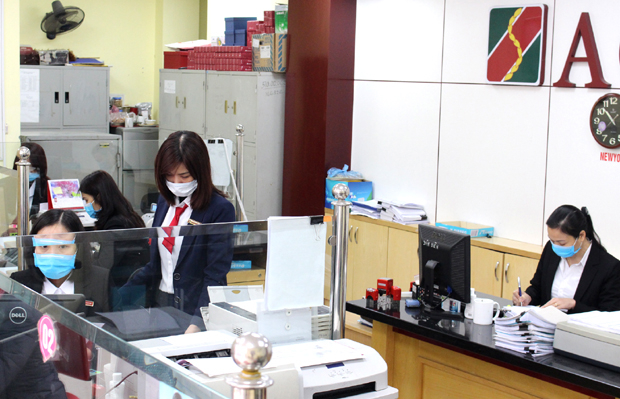 Nhân viên Phòng giao dịch Yên Biên thực hiện nghiêm quy định phòng, chống dịch.                                                                     Ảnh: Lê QUYÊN