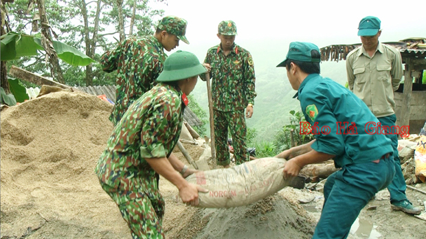 Cán bộ, chiến sỹ Ban CHQS huyện Quản Bạ vận chuyển vật liệu giúp người dân xã Tả Ván làm nhà.