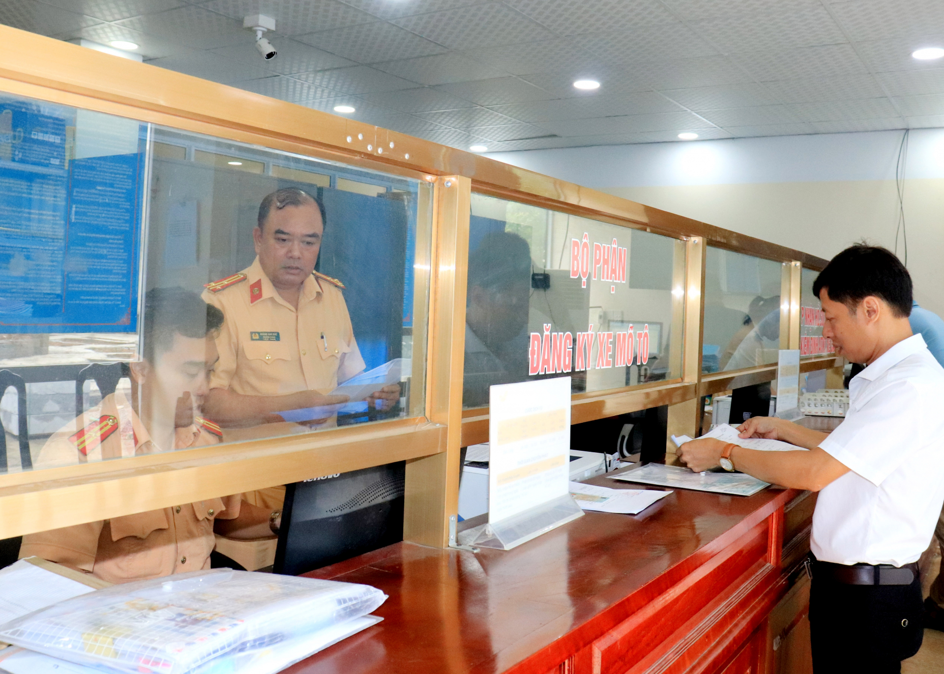 Người dân được giải quyết thủ tục hành chính tại quầy đăng ký phương tiện của Phòng Cảnh sát giao thông, Công an tỉnh. Ảnh: Bằng Lang