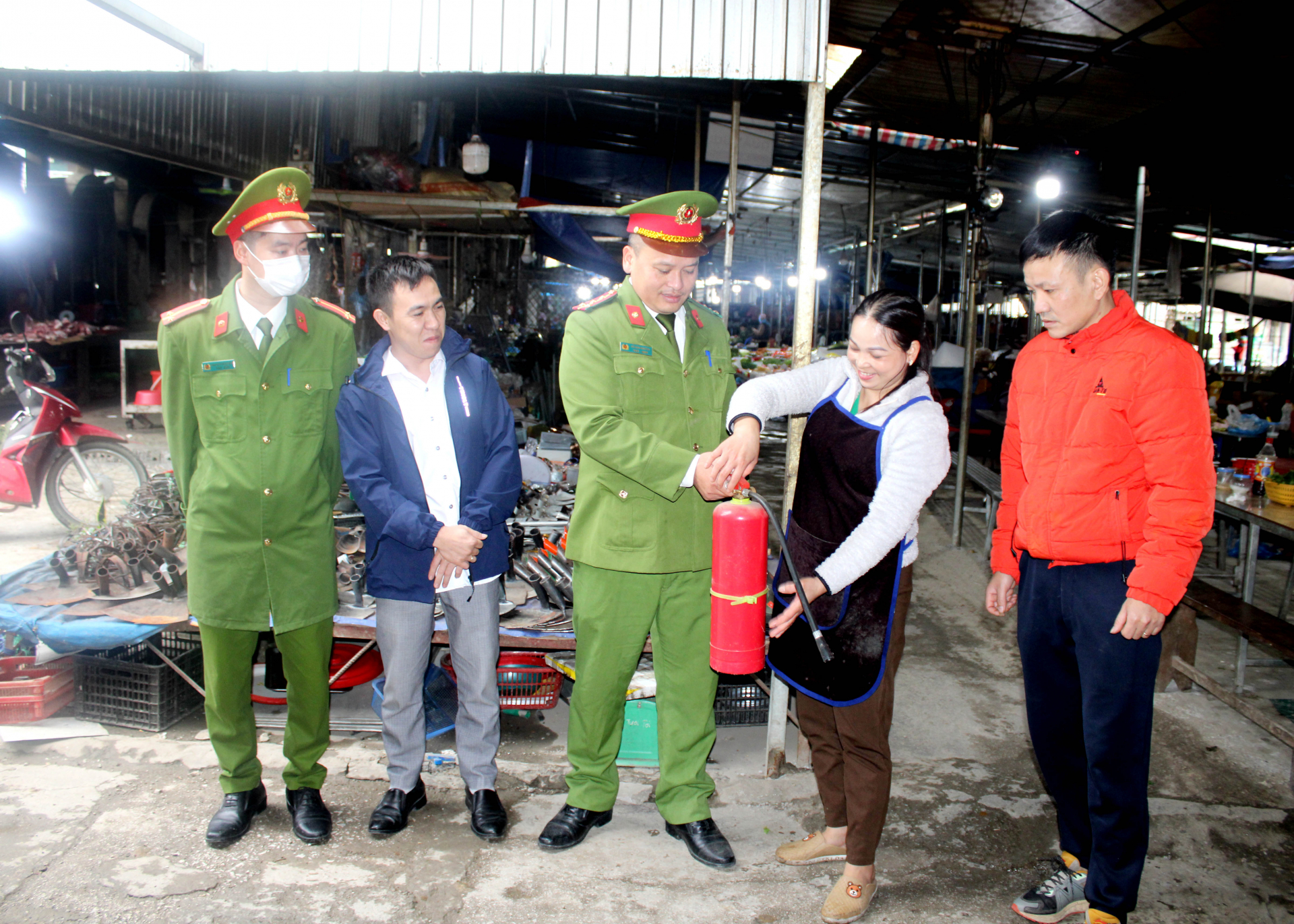 Công an thị trấn Tam Sơn hướng dẫn cách sử dụng bình chữa cháy cho các hộ kinh doanh chợ trung tâm huyện Quản Bạ.