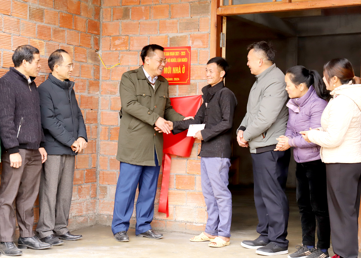 Nguyen Tien Dung, Secretary of the Dong Van District Party Committee, presents a congratulatory gift to the family of Giang Mi Xa in Pho Tro Village, Pho Bang Town, upon the completion of their new house before the Lunar New Year.