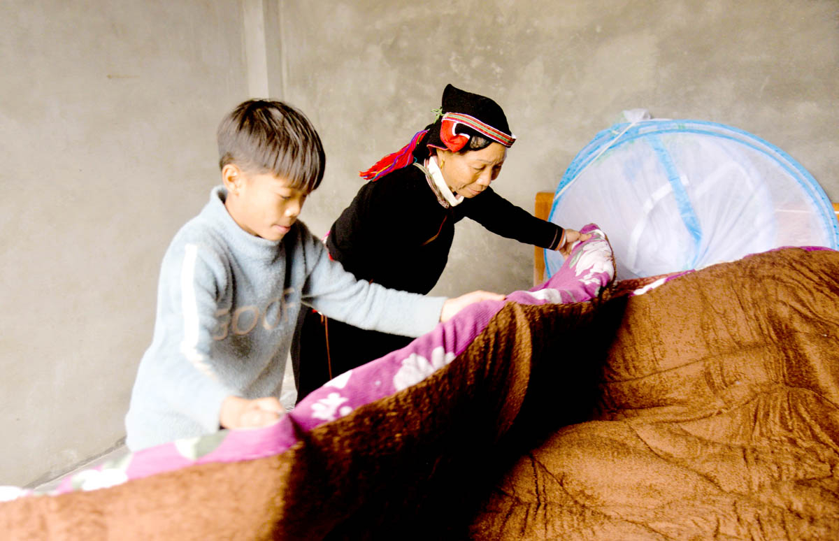 Dao ethnic Phan Thi Chap and her grandchild at their new home.