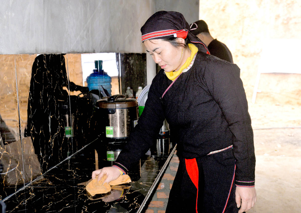 Phan Thi Quyets family members clean their belongings as they move into their new residence.