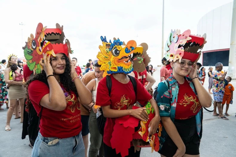 Người dân thích thú với những chiếc mũ hình rồng đón Tết Nguyên đán của người châu Á tại công viên ở Recife, Brazil.