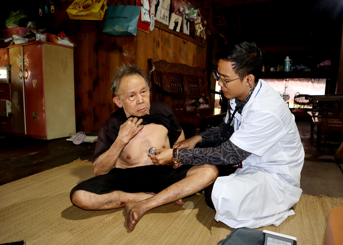 Trạm trưởng y tế xã - Trần Văn Thanh đi đến từng nhà dân để khám, chữa bệnh. Ảnh: Hồng Cừ