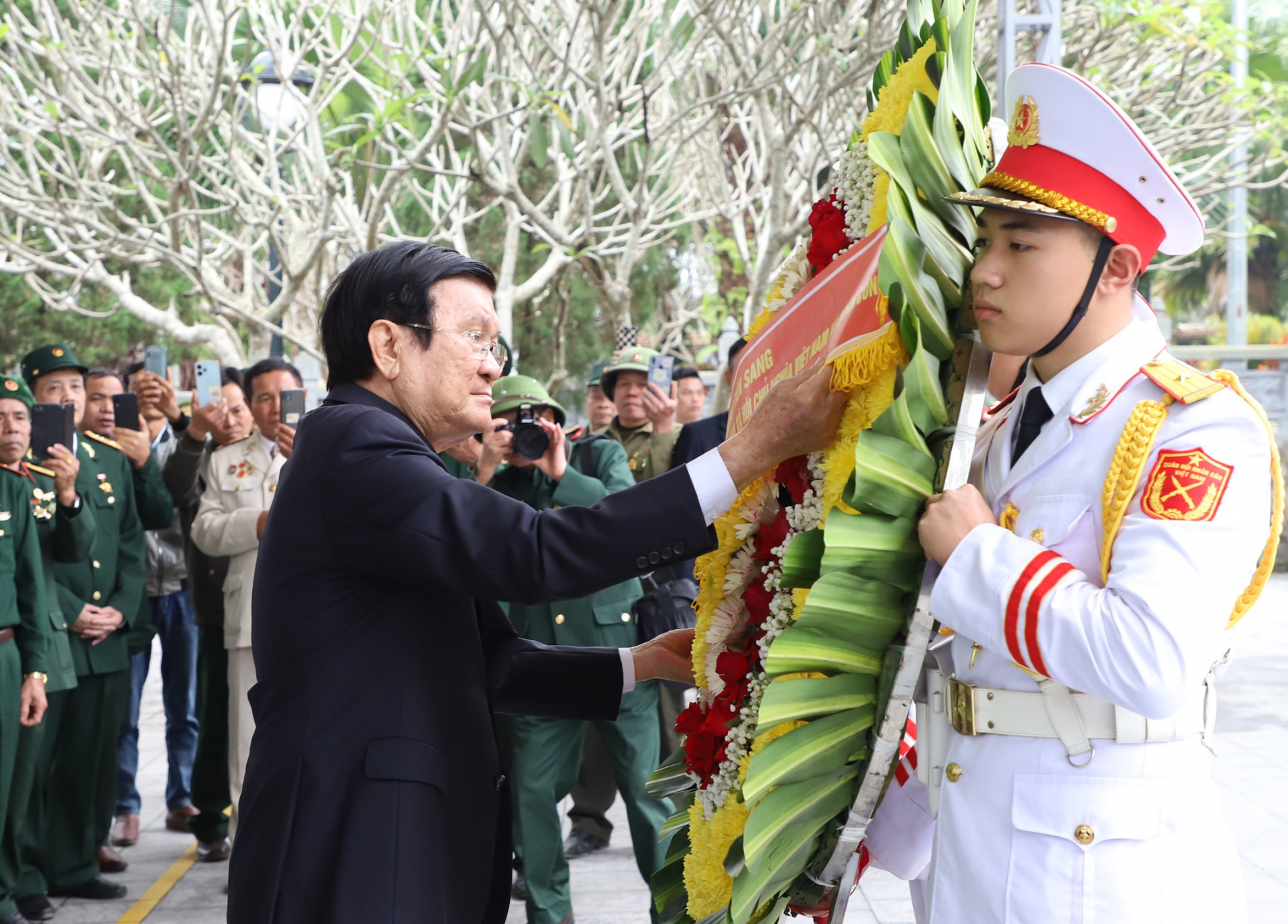 Nguyên Chủ tịch nước Trương Tấn Sang chỉnh vòng hoa trước khi dâng lên trước Tượng đài Tổ quốc ghi công tại Nghĩa trang Liệt sỹ quốc gia Vị Xuyên