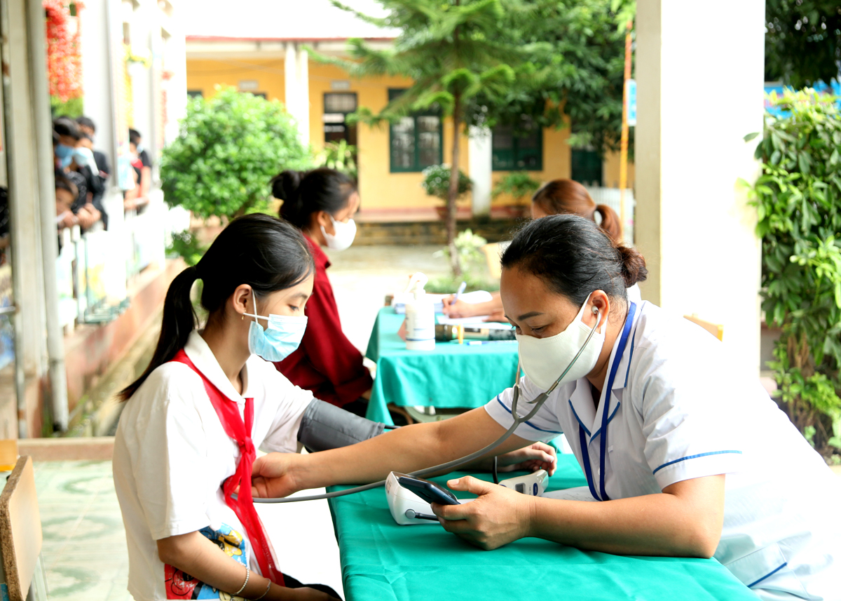 Cán bộ Trung tâm Y tế huyện Yên Minh khám sức khỏe định kỳ cho học sinh.
