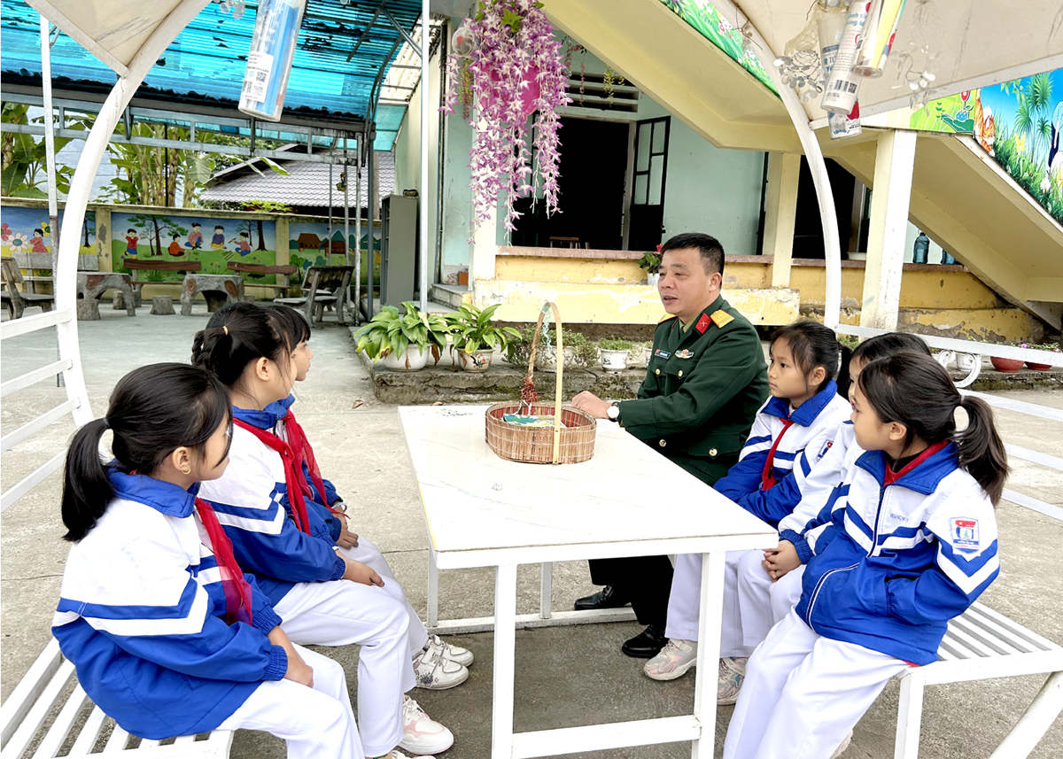 Thiếu tá Dương Minh Giới đang trò chuyện với các em học sinh Trường Tiểu học Phương Thiện (thành phố Hà Giang) về gương anh Bộ đội Cụ Hồ.