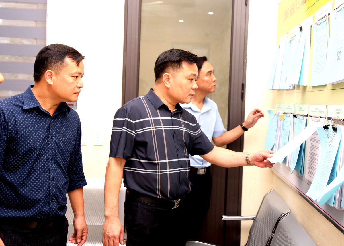 Nguyen Tien Hung, Chairman of the Xin Man District People’s Committee, inspects the posting of procedures at the district’s administrative unit.