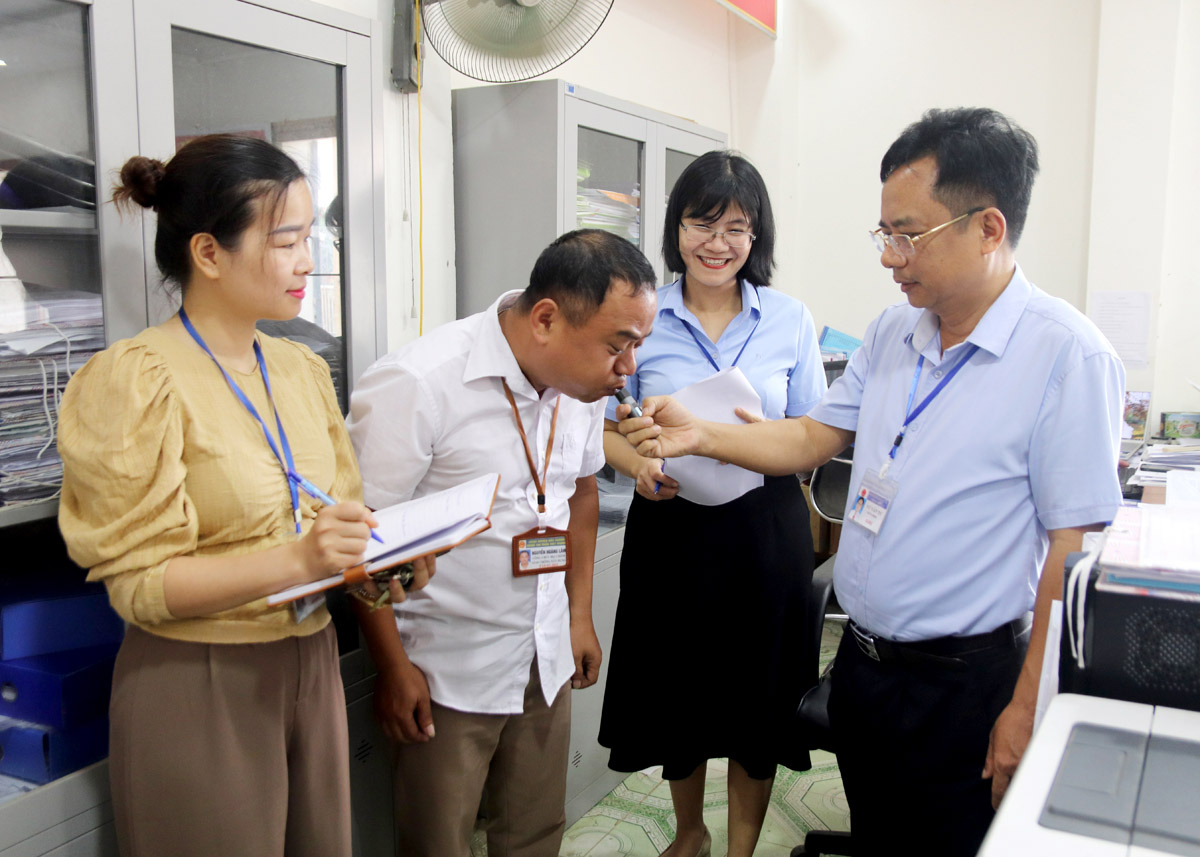 Trưởng phòng Nội vụ huyện Bắc Quang Vũ Văn Tú (bên phải) kiểm tra việc chấp hành kỷ luật, kỷ cương hành chính tại cơ sở. Đồng chí cũng là một trong những cán bộ tiên phong xin nghỉ hưu trước tuổi, dù còn 7 năm công tác.