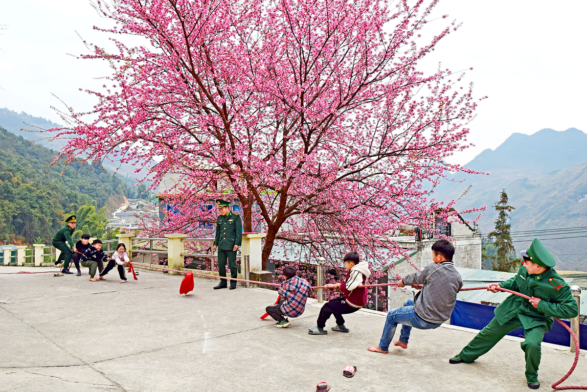 Soldiers and children join a tug of war game