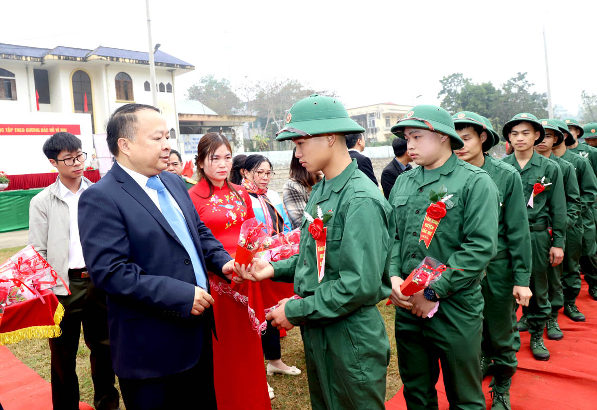 Chairman of the Ha Giang People’s Committee Phan Huy Ngoc presents flowers to encourage new recruits.