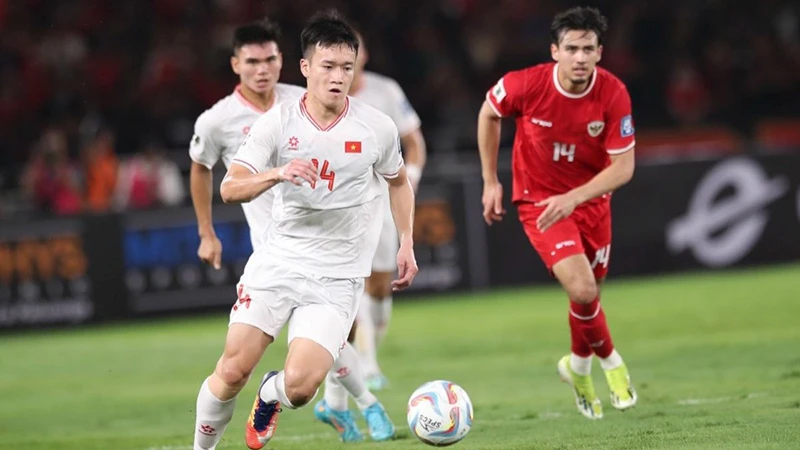 Pha tranh bóng giữa cầu thủ đội tuyển Việt Nam (áo trắng) và Indonesia ở trận lượt đi trên sân Bung Karno. 