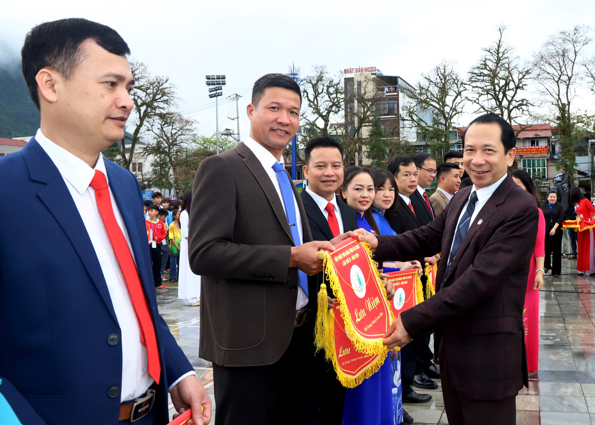 Phó Chủ tịch UBND tỉnh Trần Đức Quý tặng cờ lưu niệm cho các đoàn vận động viên.
