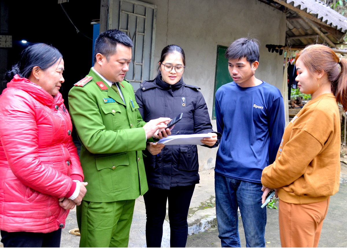 Công an huyện Quang Bình và xã Yên Thành hướng dẫn anh Hoàng Văn Dương, thôn Yên Lập đăng ký thủ tục nhận tiền trợ cấp hàng tháng cho con qua tài khoản ngân hàng.