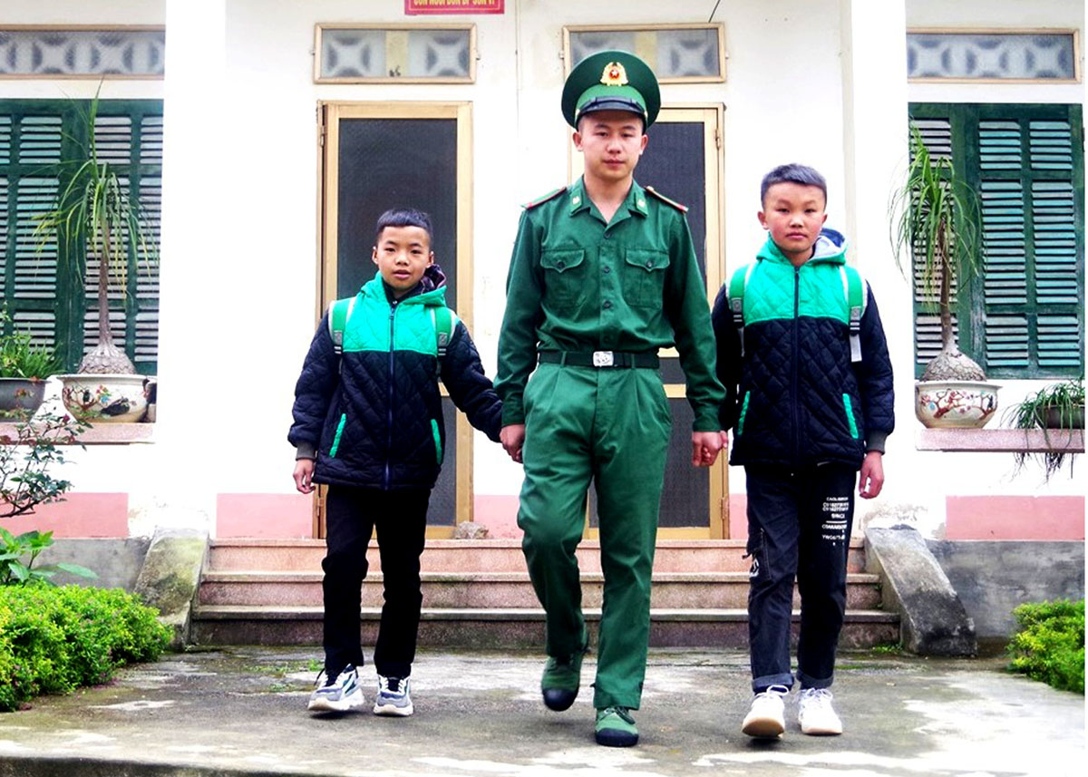 Chiến sỹ trẻ Thào Văn Tuất đưa các con nuôi của đơn vị đến trường.
