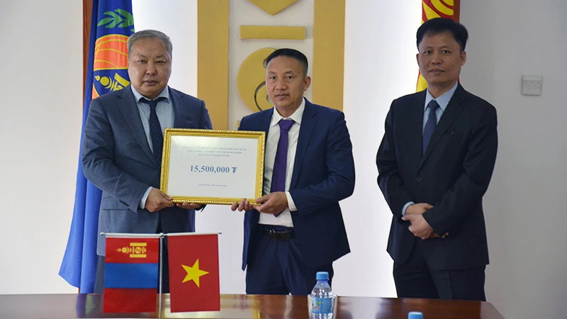 Ông Phạm Quyết Tiến, đại diện cộng đồng người Việt Nam tại Mông Cổ trao khoản tiền quyên góp cho Tổng Cục trưởng NEMA Mông Cổ G.Ariunbuyan trước sự chứng kiến của Đại sứ Việt Nam tại Mông Cổ Doãn Khánh Tâm.