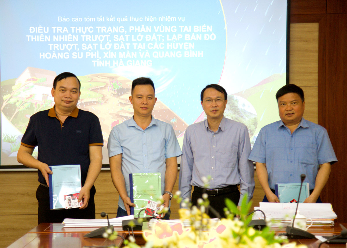 The leader of the Provincial Department of Natural Resources and Environment hands over the document on zoning and mapping of landslides to three districts of Quang Binh, Hoang Su Phi, and Xin Man