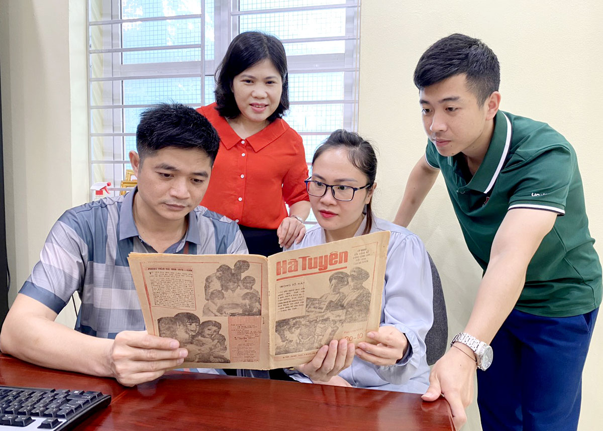 Cán bộ, phóng viên Báo Hà Giang cùng nhau xem lại một ấn phẩm của Báo Hà Tuyên.