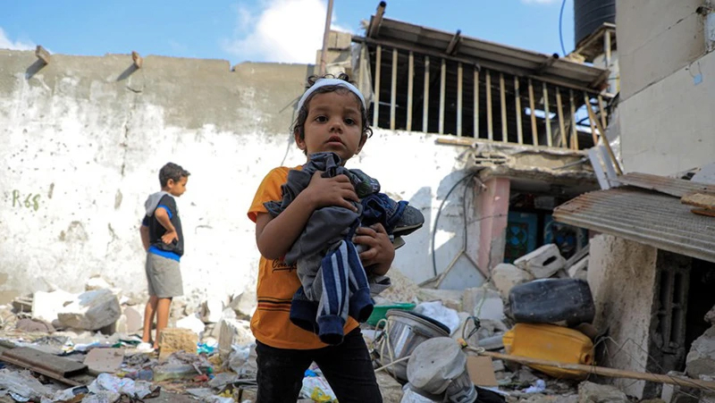 Các em nhỏ thu nhặt đồ đạc sót lại trong đống đổ nát của ngôi nhà bị phá hủy sau cuộc tấn công của Israel vào thành phố Rafah, Dải Gaza ngày 1/5/2024. 
