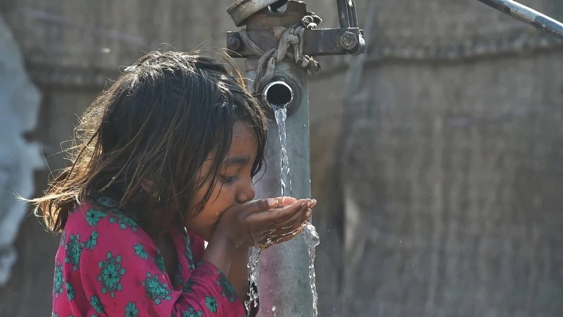 Em nhỏ uống nước từ vòi nước công cộng ở Lahore, Pakistan. 