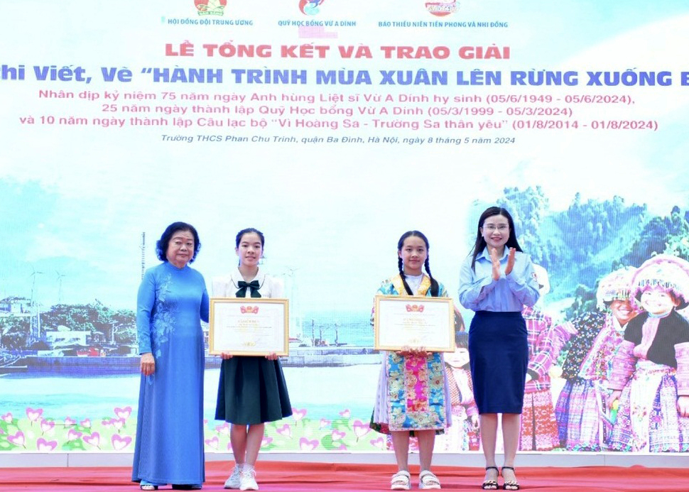 Representatives of the Vu A Dinh Scholarship Fund and the Ho Chi Minh Young Pioneer Organisation Central Council award certificates of merit to two first prize contest winners. (Vu Thanh Truc Vy stands second from right)