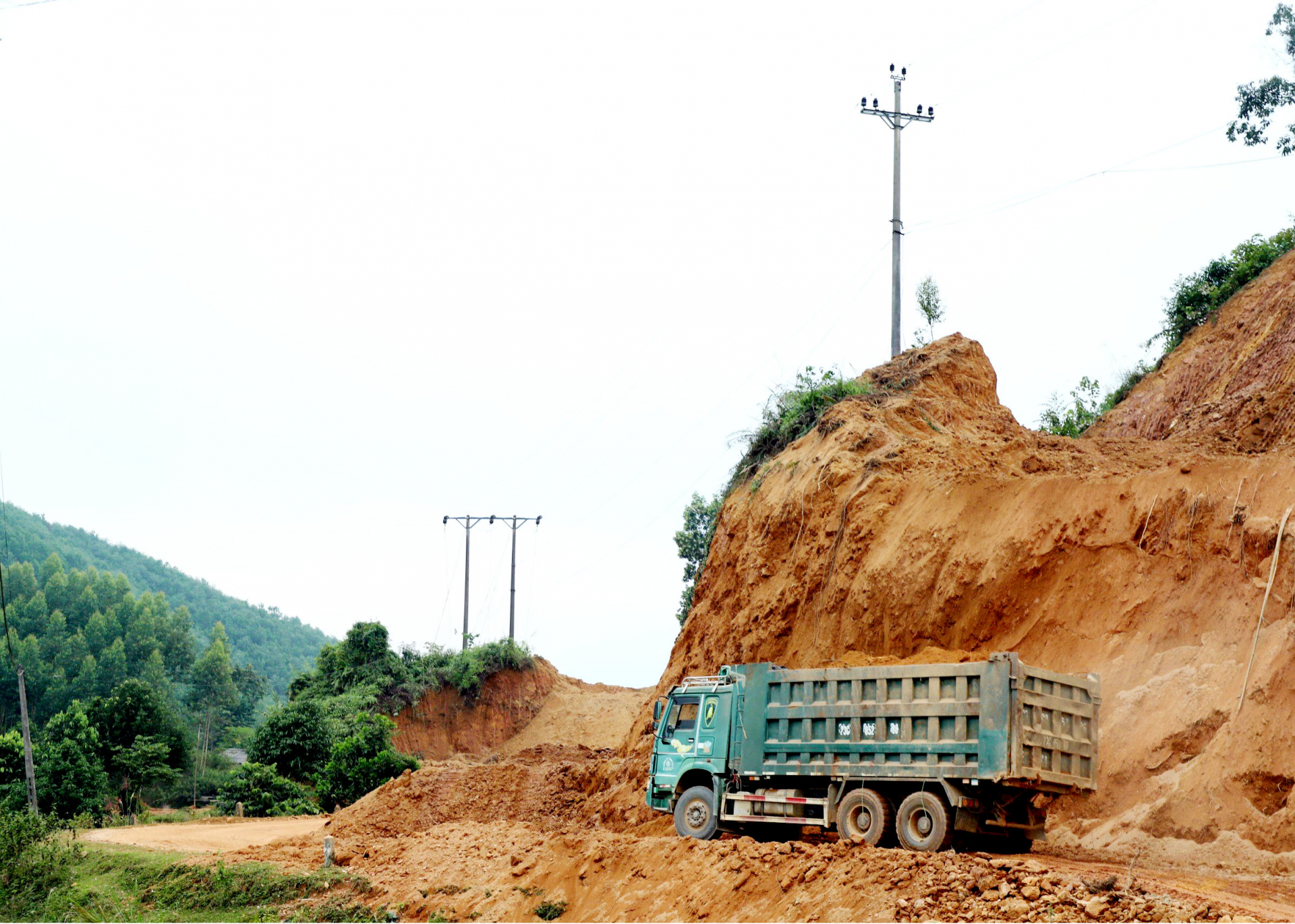 The Quang Binh - Xin Man Road (DT178) is under construction. The machines and equipment are levelling, creating land, and cutting corners.