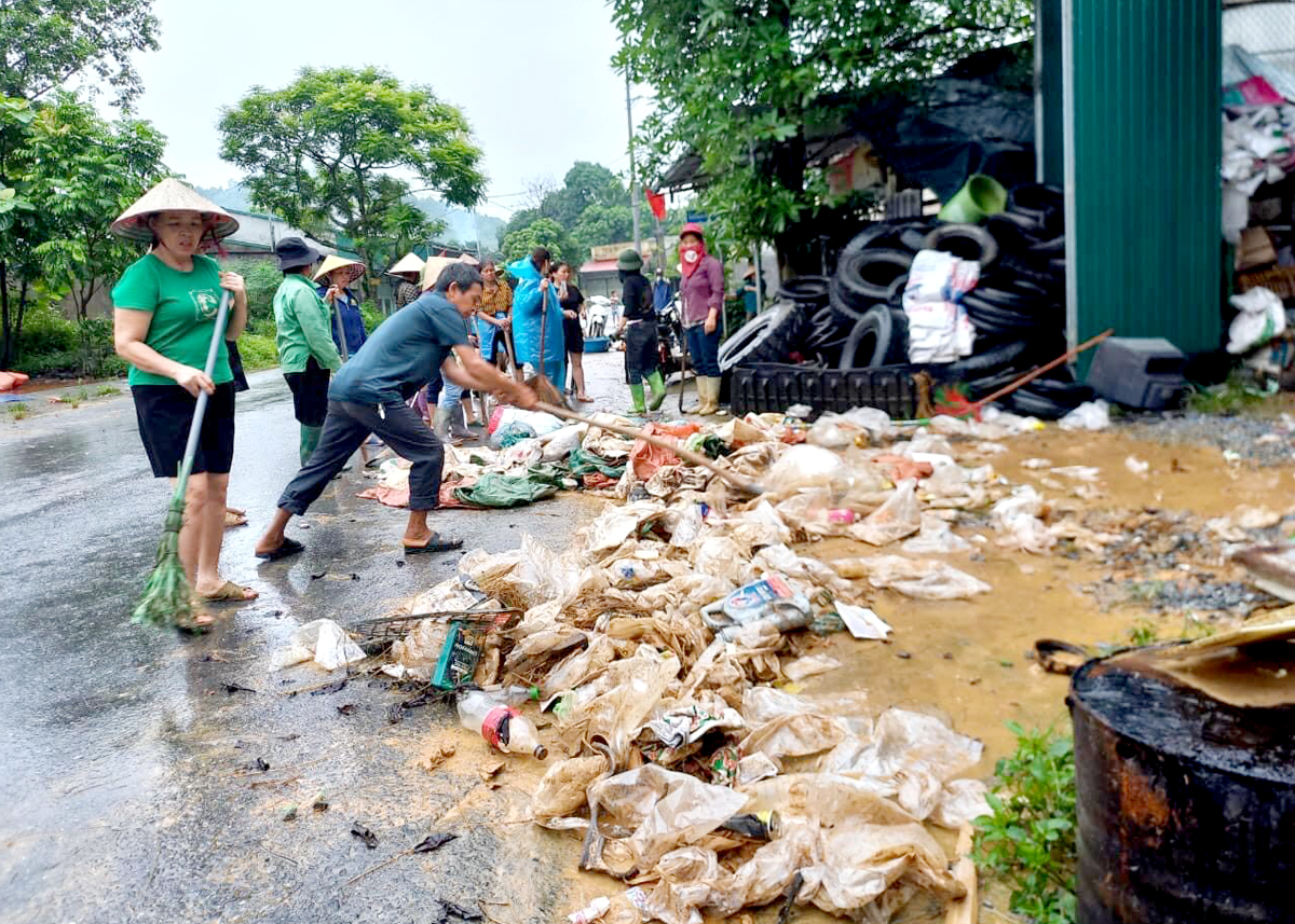 Người dân dọn dẹp rác thải sau mưa lũ.
