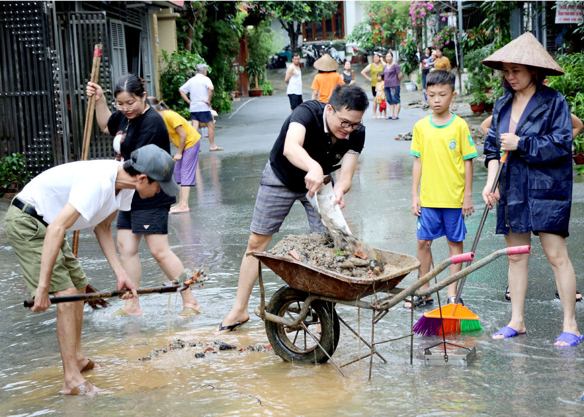 Gần 12 giờ trưa nước rút đến đâu người dân vẫn tích cực dọn dẹp, vệ sinh đường phố đến đó.