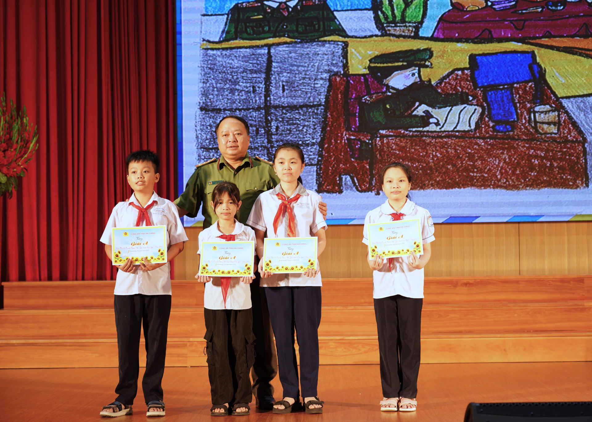 Giám đốc Công an tỉnh Phan Huy Ngọc trao phần thưởng cho các cháu đạt giải A cuộc thi vẽ tranh “Gia đình em yêu”.