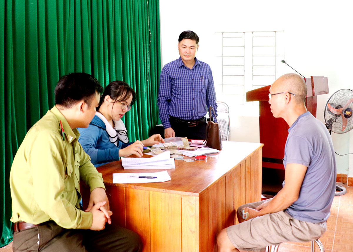 Người dân thôn Bản Khén, xã Lạc Nông (Bắc Mê) nhận tiền dịch vụ môi trường rừng tại nhà văn hóa thôn.