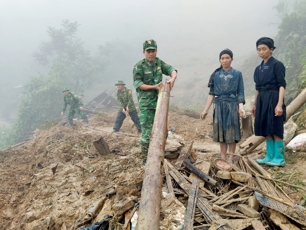 Cán bộ, chiến sỹ Đồn Biên phòng Cửa khẩu Xín Mần giúp dân khắc phục hậu quả thiên tai.
