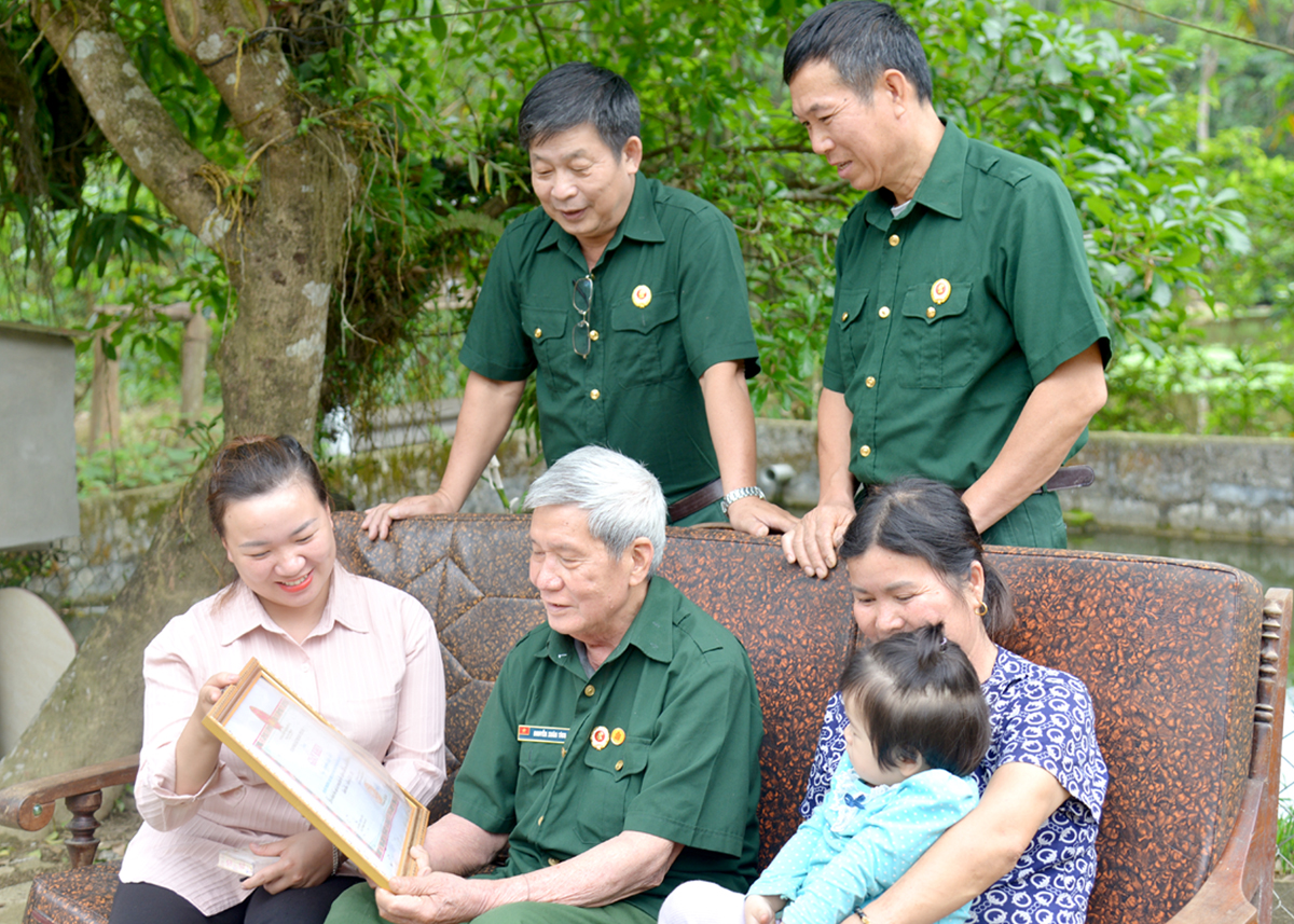 Cựu chiến binh Nguyễn Xuân Tích (ngồi giữa) ôn lại những năm tháng chiến đấu chống Mỹ cứu nước.